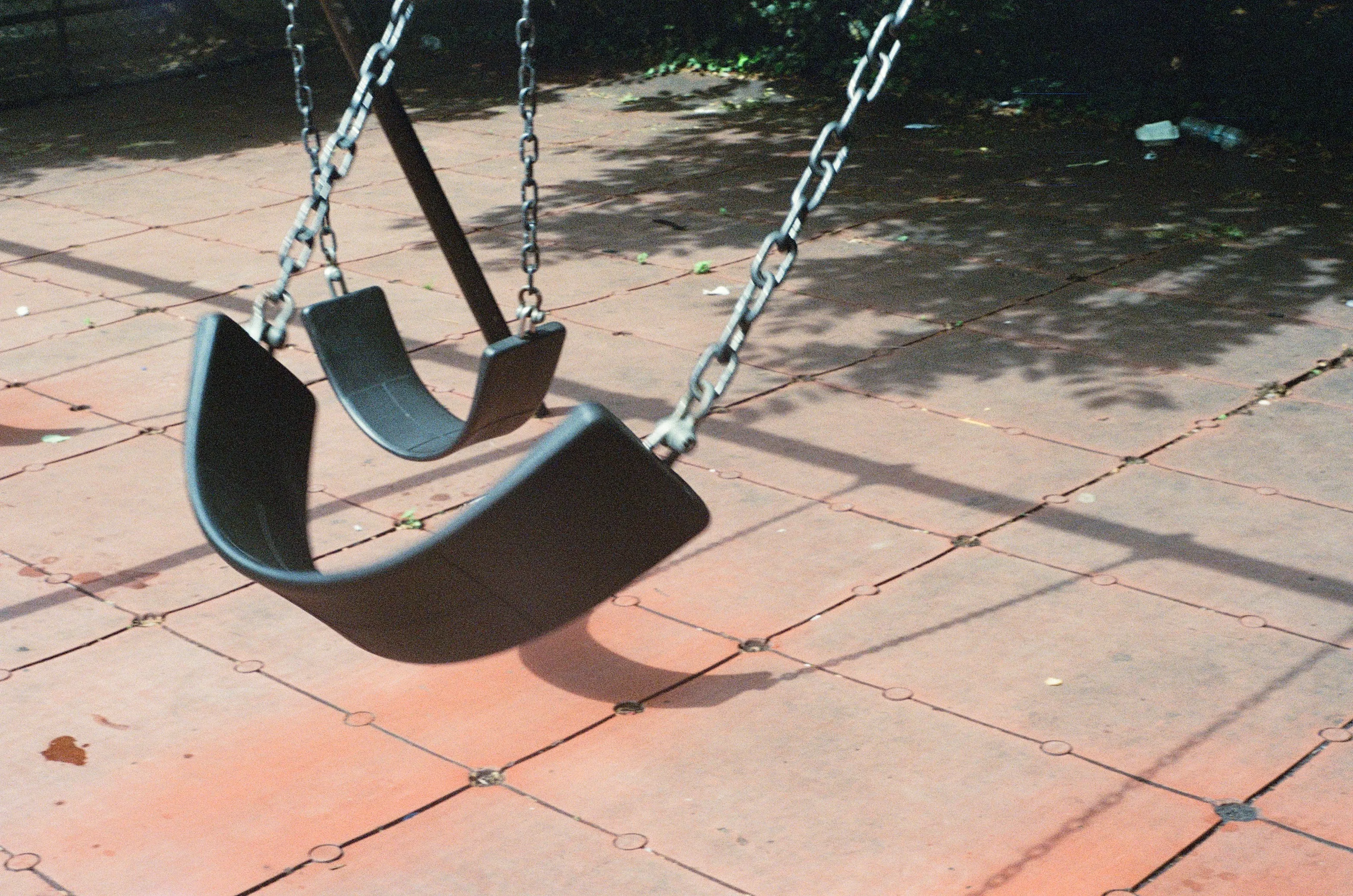 Empty swings on a sunlit playground